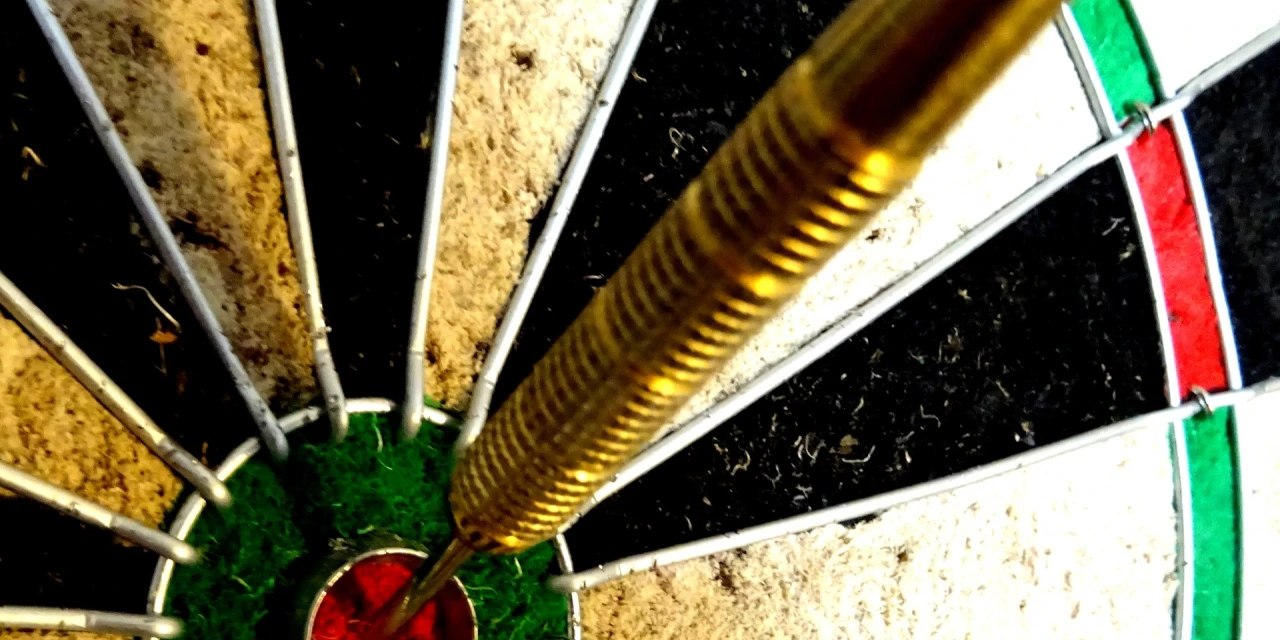 Dart in dartboard bullseye close up