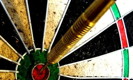 Dart in dartboard bullseye close up